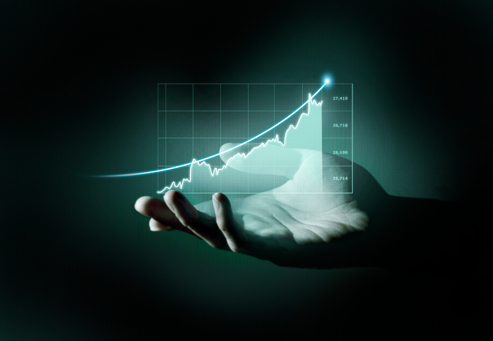 A hand is shown holding a holographic, upward-trending line graph. The dark background emphasizes the glowing, transparent graph, which represents financial growth or positive business trends. The image conveys themes of technological advancement, data visualization, and successful financial management.