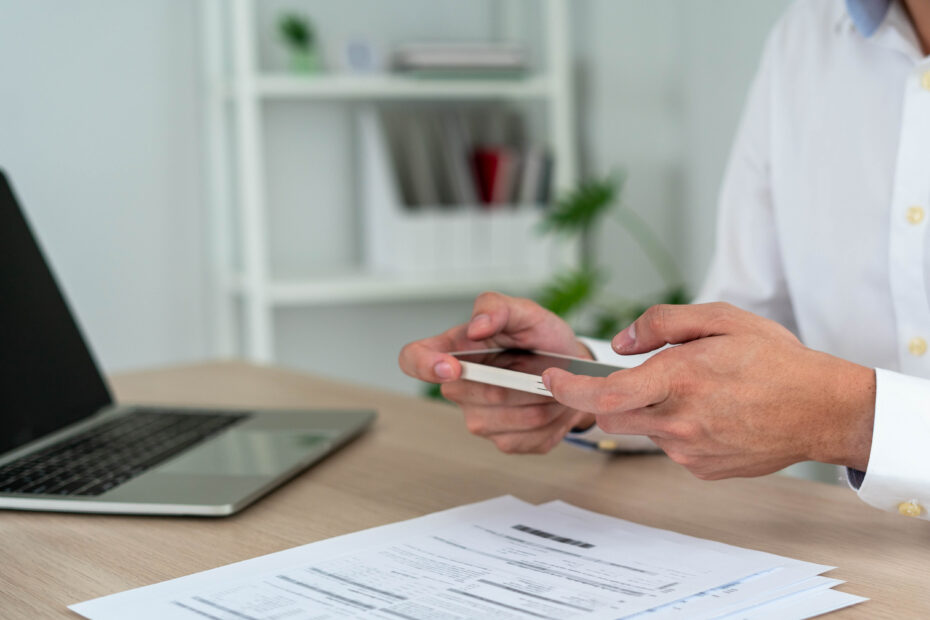 Businessmen use mobile phones to scan barcodes to access accounting information within the company.