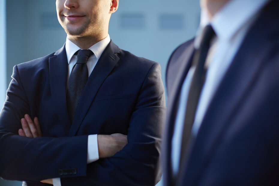 Cropped image of a confident businessman standing near his colleague on the foreground